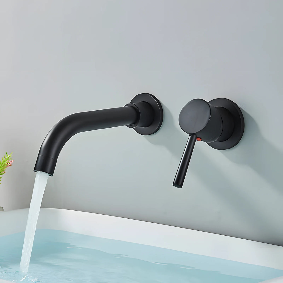 Mitigeur mural encastré noir mat au-dessus d'une baignoire, bec et manette sur rosaces rondes