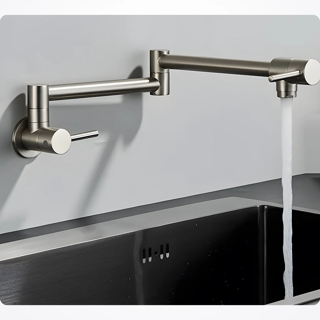 Robinet mural rabattable nickel brossé déplié au-dessus d'un évier en inox noir, jet d'eau froide ouvert