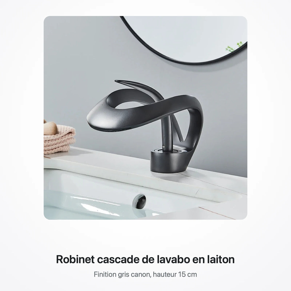 Robinet cascade gris canon posé sur un lavabo blanc, devant un miroir rond