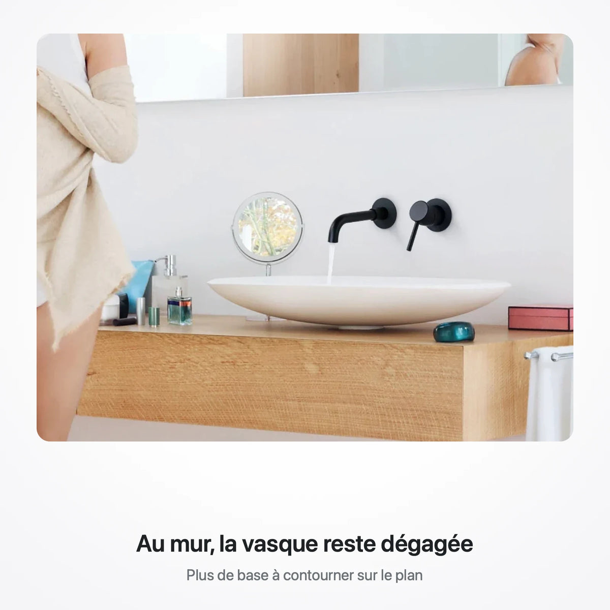 Robinet mural noir mat au-dessus d'une vasque à poser ovale, sur un plan de salle de bain en chêne