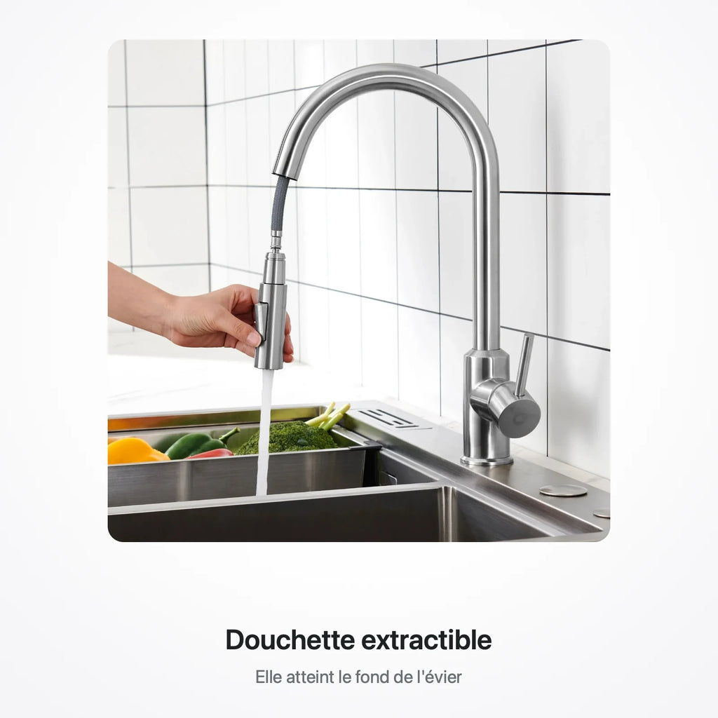 Main tenant la douchette extractible pour rincer des légumes au fond de l'évier