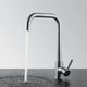 Robinet col de cygne en inox brossé, eau qui coule en filet, vu de profil