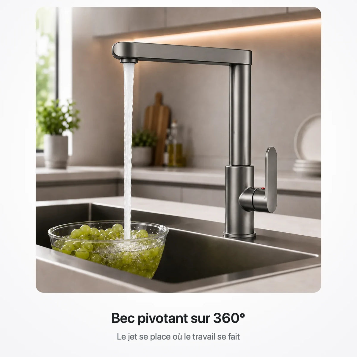 Robinet de cuisine gris en écoulement au-dessus d'un saladier de raisin posé dans un évier en inox