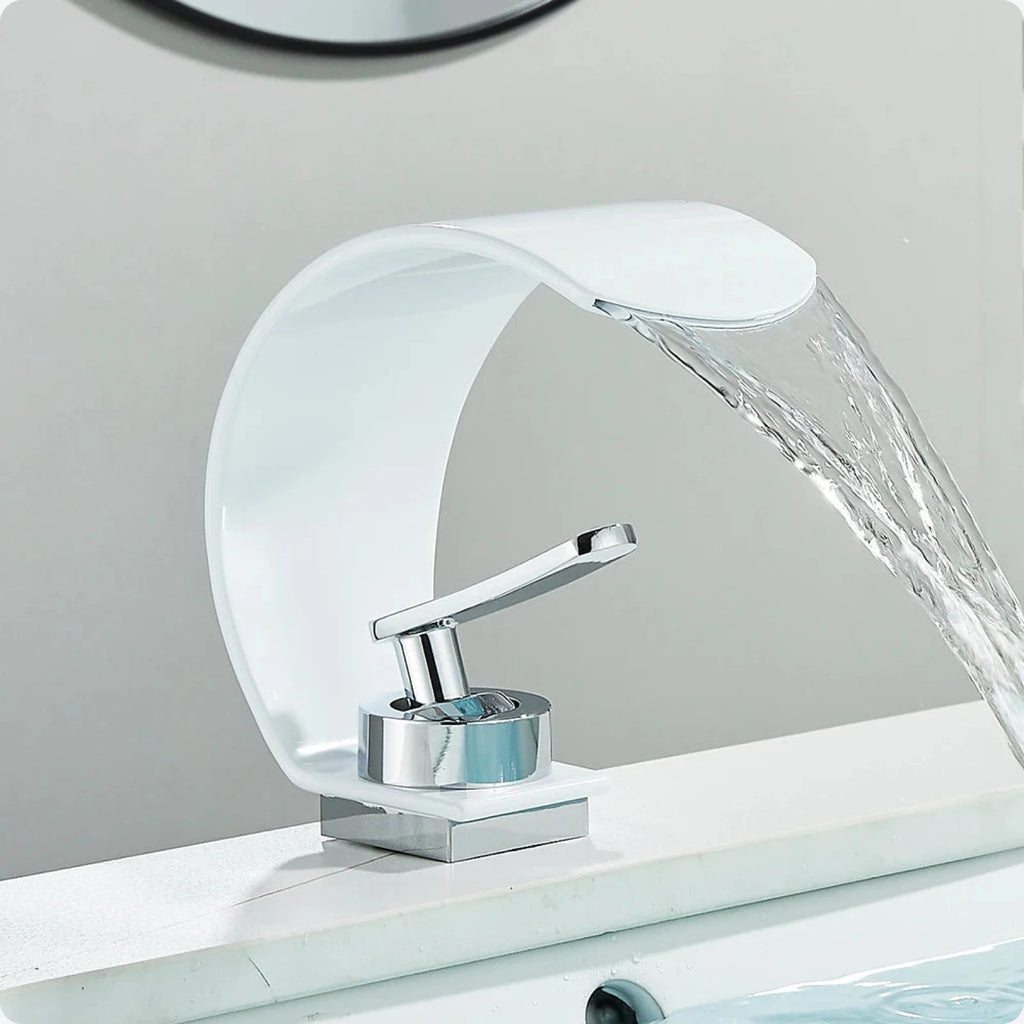 Robinet en cascade blanc et chromé posé sur un lavabo, eau tombant en nappe