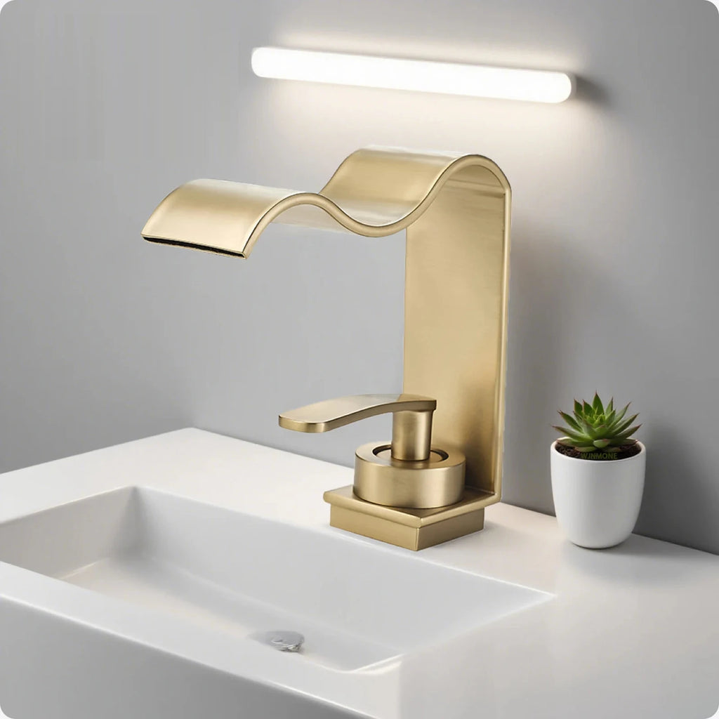 Robinet lavabo cascade or brossé sur un plan de vasque
