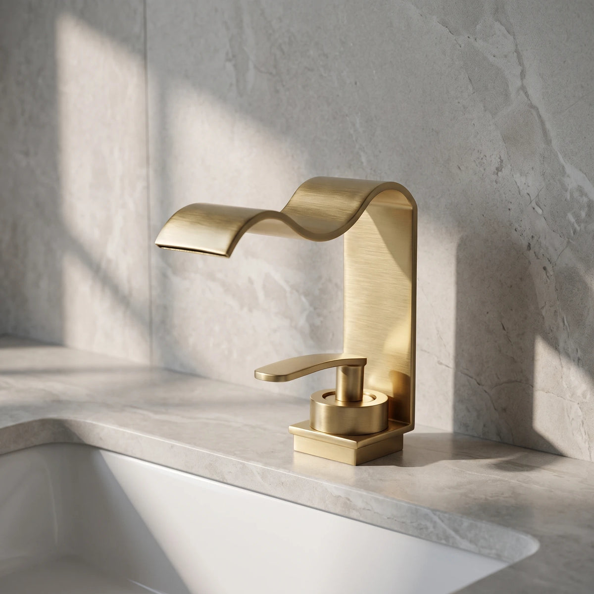 Robinet de lavabo à bec cascade en or brossé, posé sur un plan de pierre claire